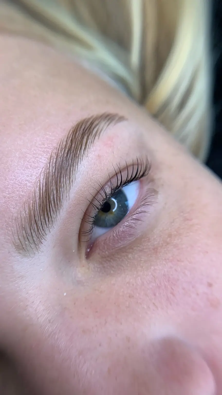 Brow Lamination em cliente loira de olhos azuis com fios alinhados e naturais